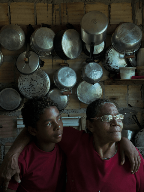 Caio and his grandmother, Maria, in her kitchen in the Bairro Novo favela.