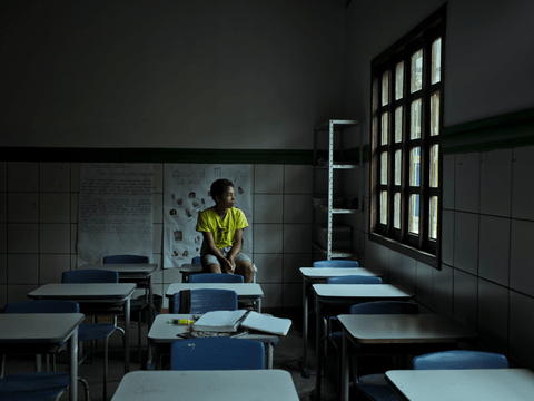 Caio sits for a portrait in a classroom at his school.