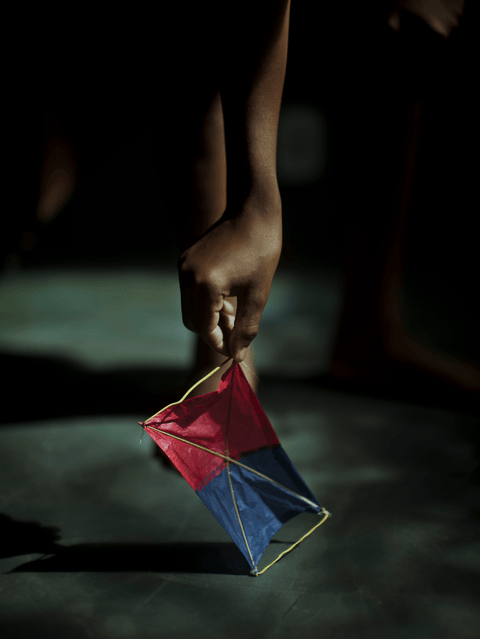 Caio holds a mask he fashioned from the same materials he uses to make kites.