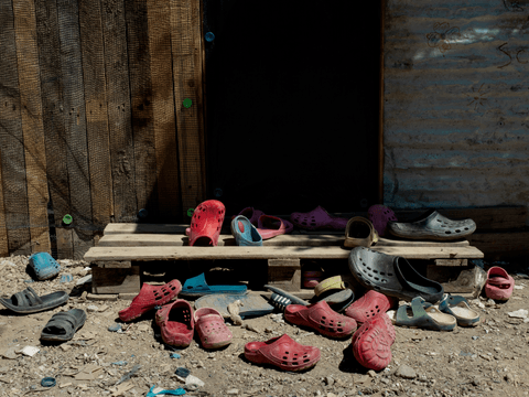 Children's shoes sit outside the "School of Stars", a site run by friends (not pictured) Manjia, 13 and Atefe, 11, in Moria Reception and Identification Centre.