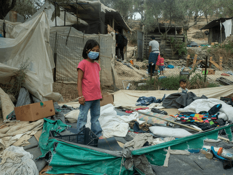 Masha stands at her family’s former tent site at the burnt-out Moria Reception and Identification Centre.