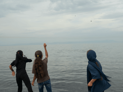 Manija spends time throwing stones into the Aegean Sea.