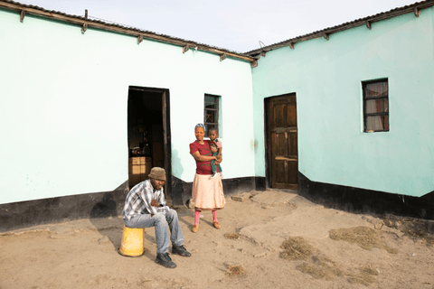 Thandeka, Indamkle and his father rest outside their home.