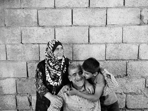 Ali (right), 14, father Halit (centre), 47, and mother Souda, 55, share a tender moment in the backyard of their home in Istasyon.
