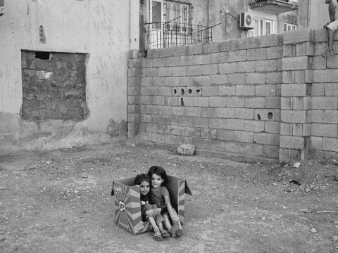 Children play inside a box in the Istasyon neighbourhood of Mardin.